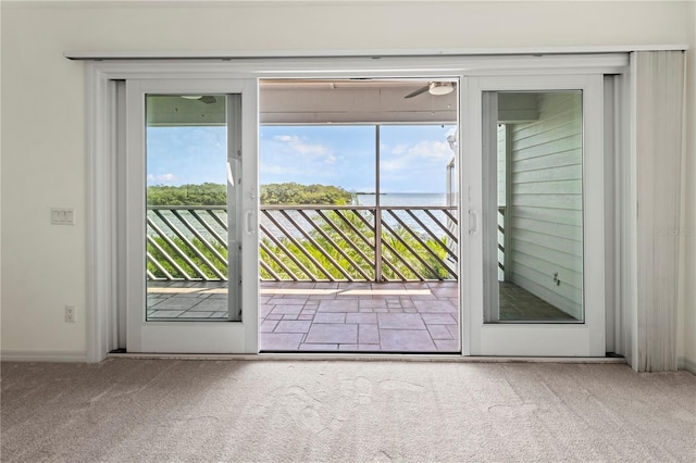 entryway featuring a water view and light colored carpet