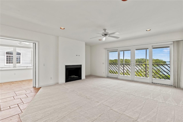 unfurnished living room with ceiling fan and light carpet