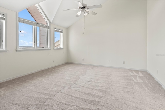 spare room with light carpet, ceiling fan, and vaulted ceiling