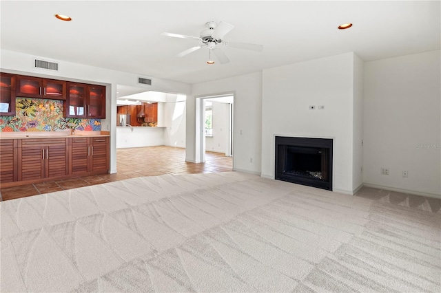 unfurnished living room with light carpet and ceiling fan