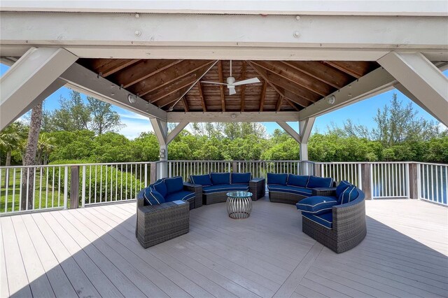 wooden deck featuring outdoor lounge area, ceiling fan, and a gazebo