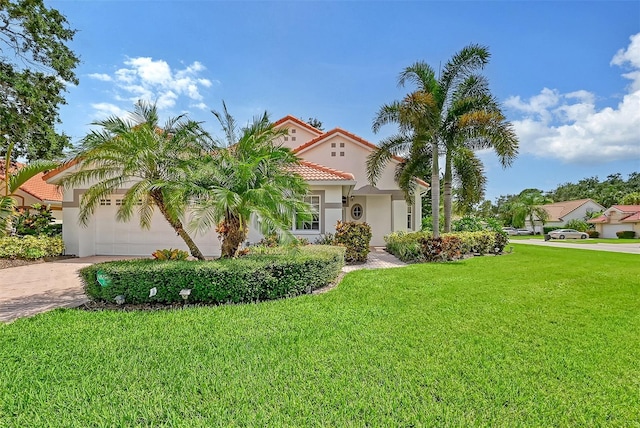 mediterranean / spanish home with an attached garage, a tile roof, decorative driveway, stucco siding, and a front yard