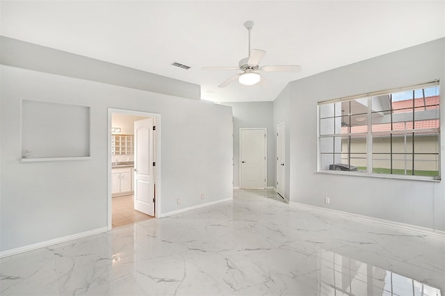 tiled spare room featuring ceiling fan