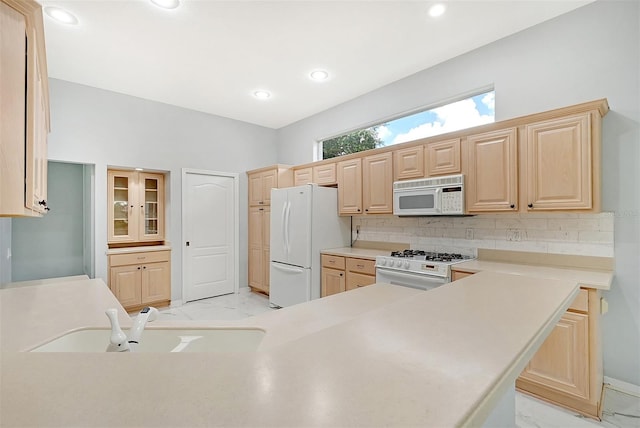 kitchen featuring sink, light brown cabinetry, white appliances, and light tile patterned floors