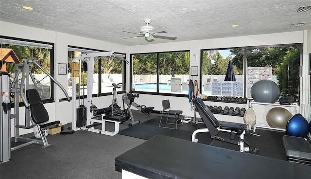 workout area with a textured ceiling, visible vents, and a ceiling fan