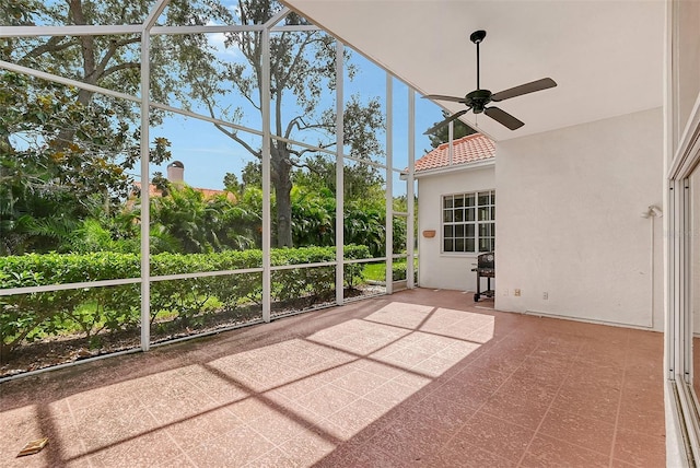 unfurnished sunroom featuring ceiling fan and a healthy amount of sunlight