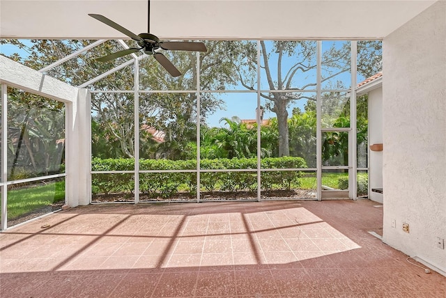 unfurnished sunroom featuring ceiling fan