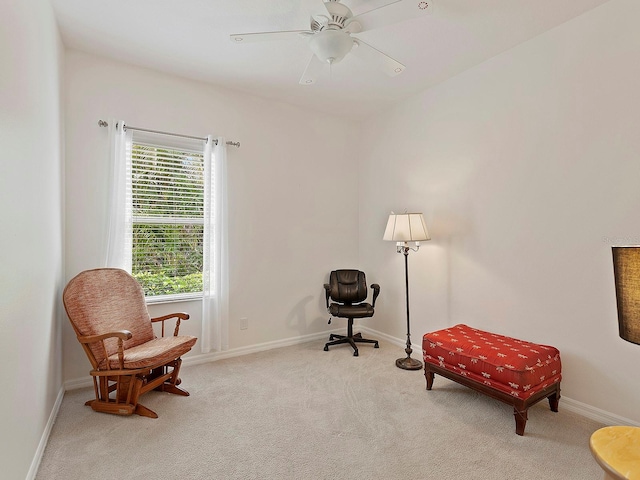 living area featuring carpet flooring and ceiling fan