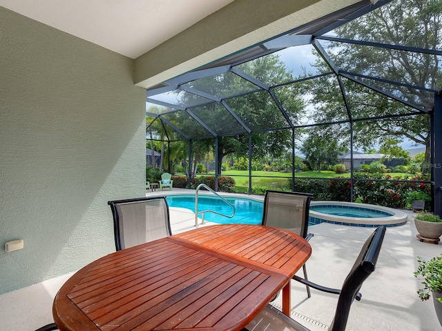 view of pool featuring glass enclosure, an in ground hot tub, and a patio area