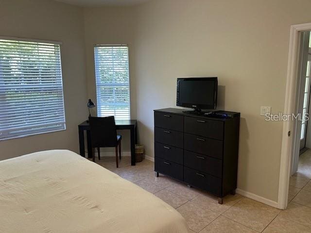 tiled bedroom featuring multiple windows