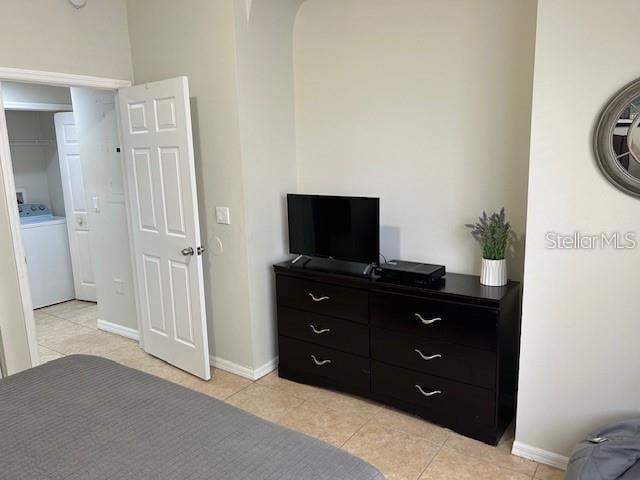 tiled bedroom featuring washer / dryer