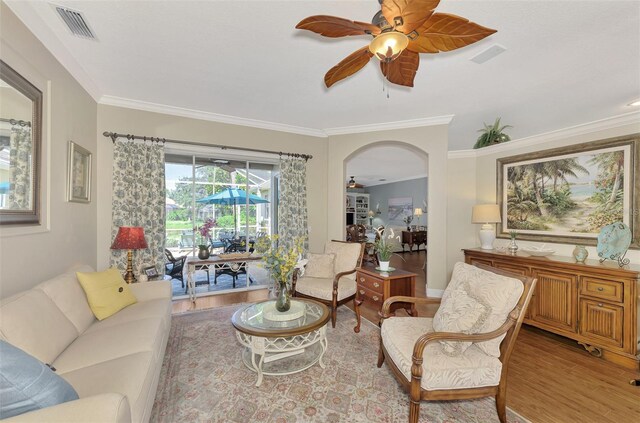 living room with ceiling fan, light hardwood / wood-style flooring, and crown molding