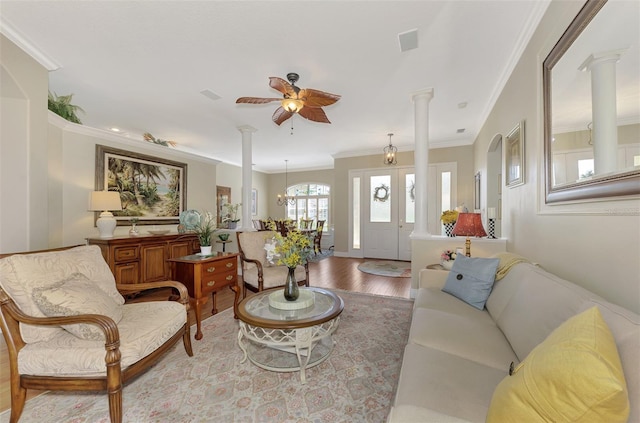 living room featuring crown molding, ceiling fan with notable chandelier, decorative columns, and hardwood / wood-style flooring