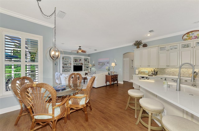 dining area featuring ceiling fan, crown molding, and wood-type flooring