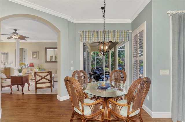 dining room with hardwood / wood-style floors, ceiling fan with notable chandelier, and crown molding