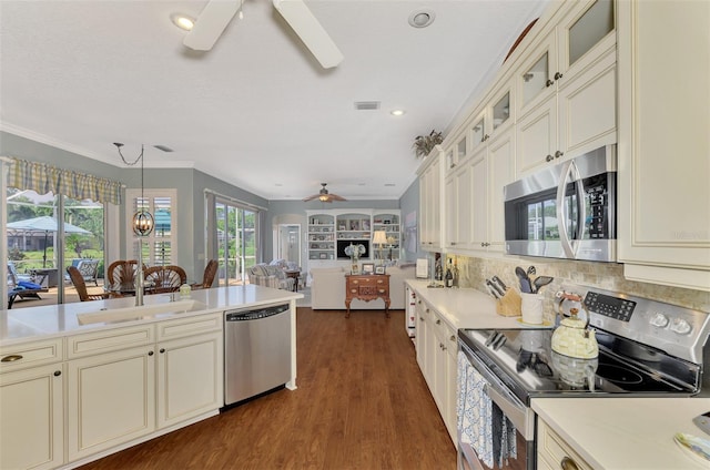 kitchen with ceiling fan, dark wood-type flooring, sink, crown molding, and stainless steel appliances