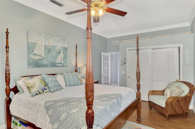 bedroom featuring ceiling fan, ornamental molding, a closet, and wood-type flooring