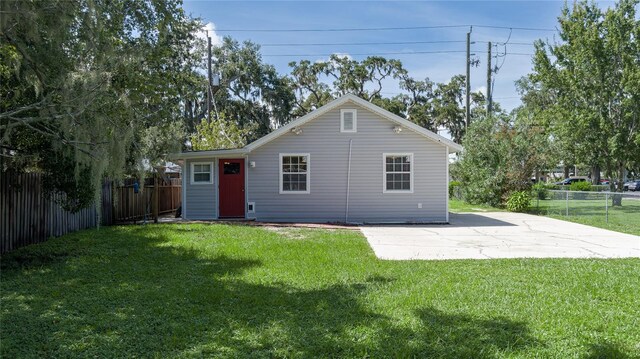 rear view of property featuring a yard and a patio