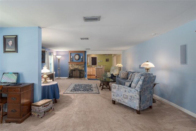 carpeted living room featuring a stone fireplace