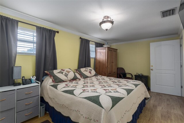 bedroom featuring crown molding, multiple windows, and wood-type flooring