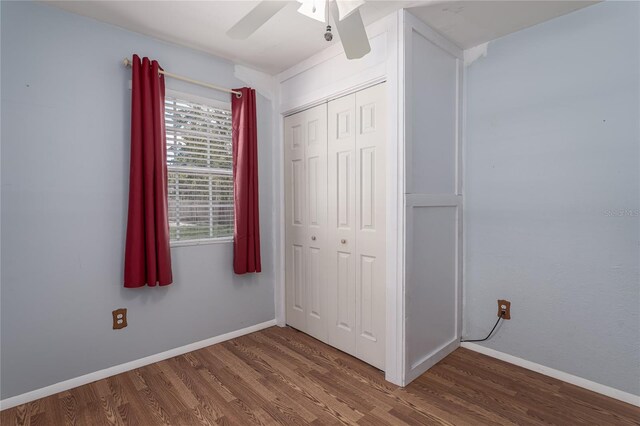 unfurnished bedroom featuring a closet, wood-type flooring, and ceiling fan