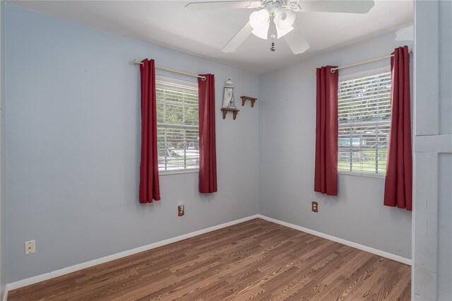 spare room featuring ceiling fan, a wealth of natural light, and hardwood / wood-style flooring