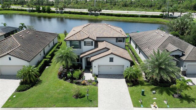 view of front of property featuring a water view, a garage, and a front yard