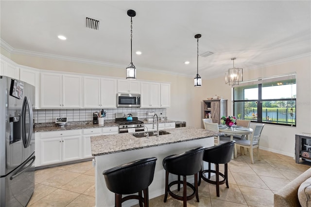 kitchen featuring backsplash, appliances with stainless steel finishes, light stone countertops, sink, and decorative light fixtures