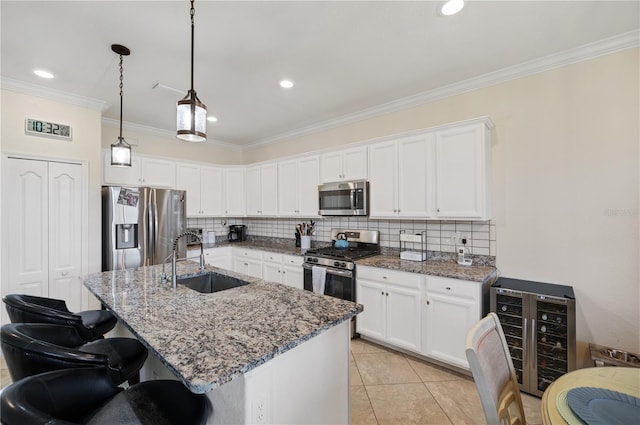 kitchen with sink, appliances with stainless steel finishes, tasteful backsplash, light tile patterned floors, and beverage cooler