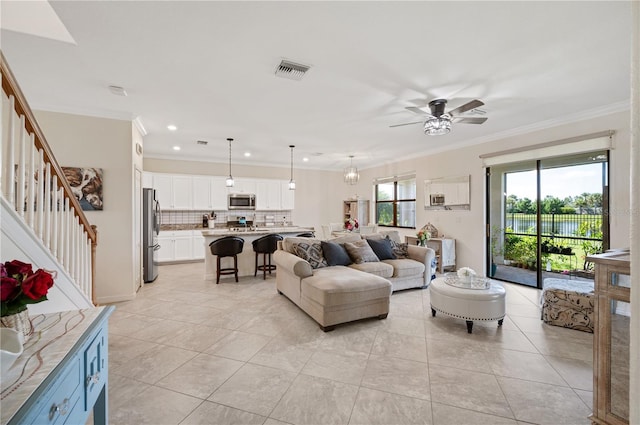 living room featuring ceiling fan, light tile patterned floors, and ornamental molding