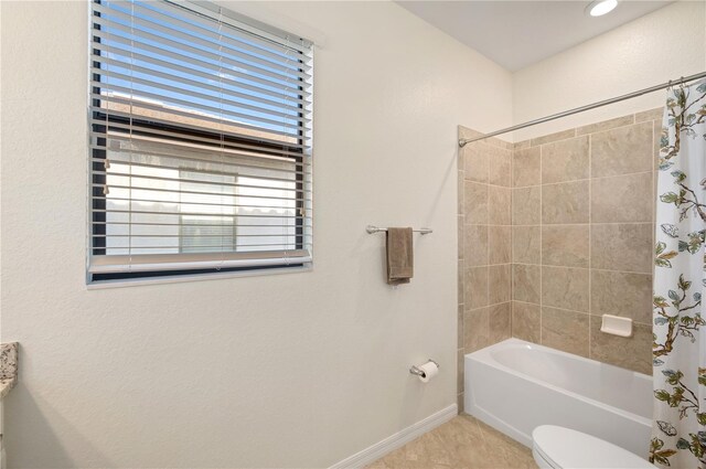 bathroom featuring tile patterned floors, shower / bath combo, and toilet