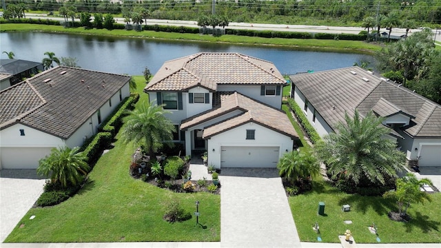 view of front of house featuring a front yard, a garage, and a water view