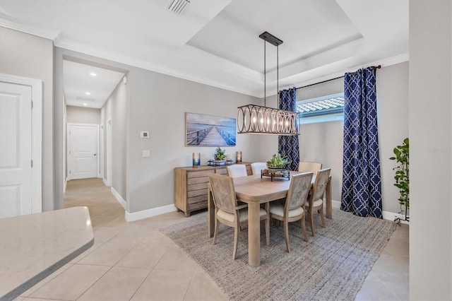 dining area featuring light tile patterned floors, ornamental molding, and a tray ceiling