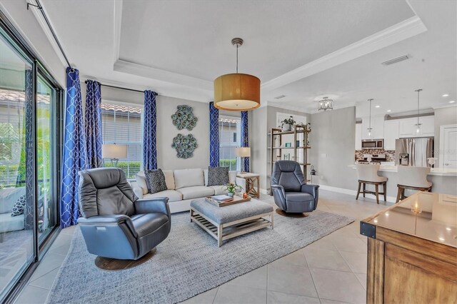 tiled living room featuring ornamental molding and a raised ceiling