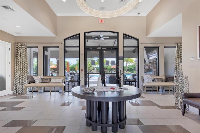 interior space featuring a high ceiling, french doors, and ceiling fan