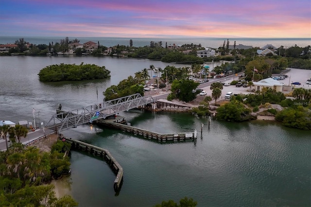 aerial view at dusk featuring a water view