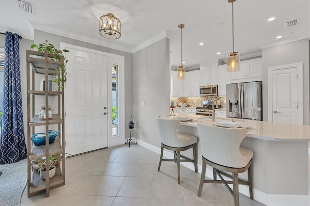 tiled foyer entrance featuring a notable chandelier and crown molding