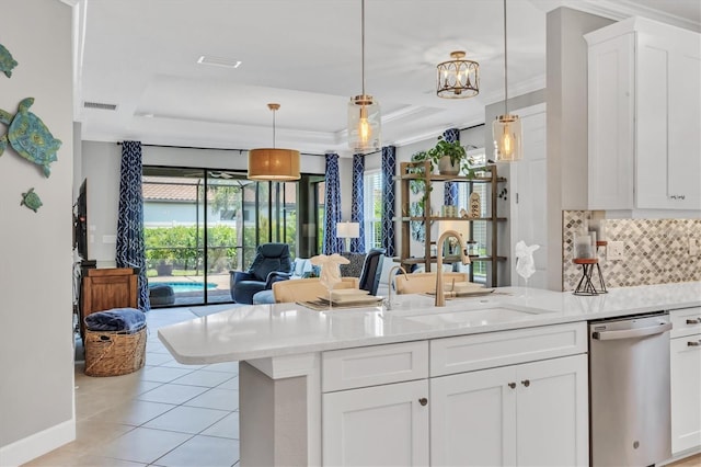 5732 Puccini St, Nokomis, FL 34275 - kitchen with stainless steel dishwasher, a tray ceiling, light tile patterned floors, backsplash, and open floor plan