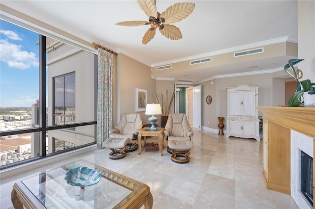 living area with light tile patterned flooring, ceiling fan, crown molding, a wall of windows, and a high end fireplace