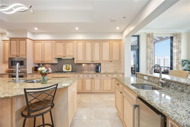 kitchen featuring a sink, a breakfast bar area, and light stone countertops