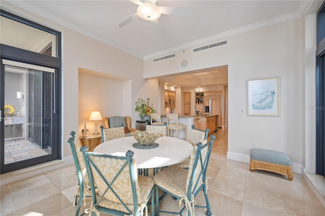 tiled dining room featuring ceiling fan and crown molding