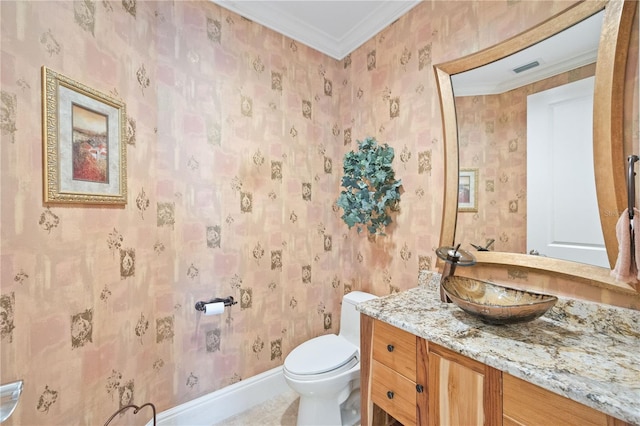 bathroom with toilet, vanity, and ornamental molding