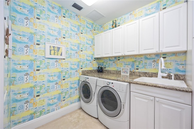 washroom featuring cabinet space, a sink, separate washer and dryer, and wallpapered walls