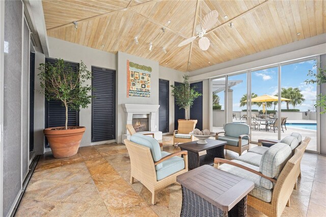 sunroom featuring wood ceiling, ceiling fan, and track lighting