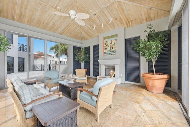 sunroom with ceiling fan and wooden ceiling