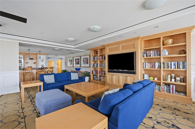 living area featuring french doors, a raised ceiling, and built in features