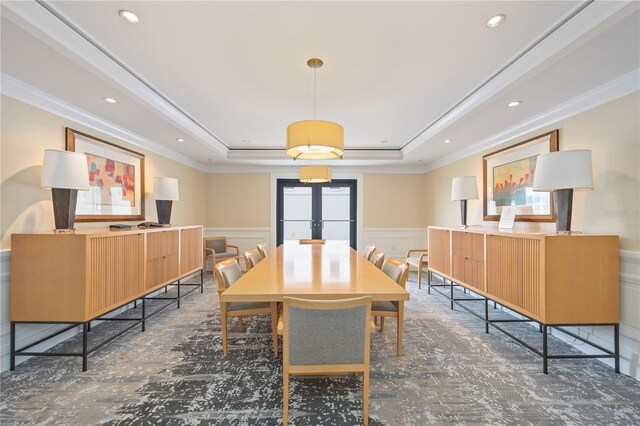 dining space with a tray ceiling and ornamental molding