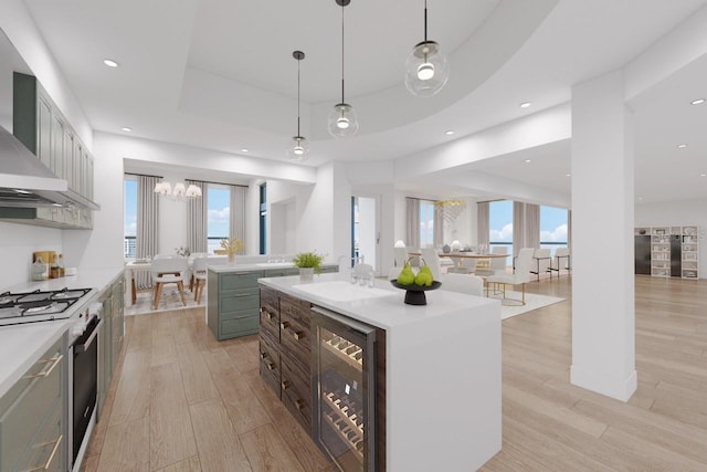 kitchen featuring a kitchen island, gas range gas stove, wine cooler, a tray ceiling, and light wood-style floors