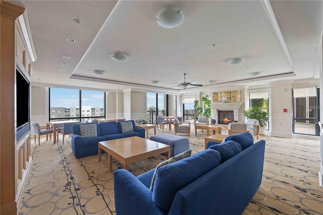 50 Central Ave Unit 17Phb, Sarasota, FL 34236 - living room featuring a raised ceiling, a decorative wall, plenty of natural light, a warm lit fireplace, and a ceiling fan