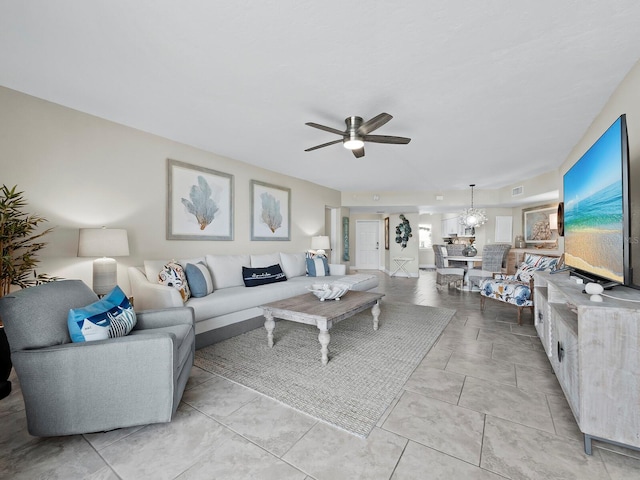 living room with ceiling fan with notable chandelier